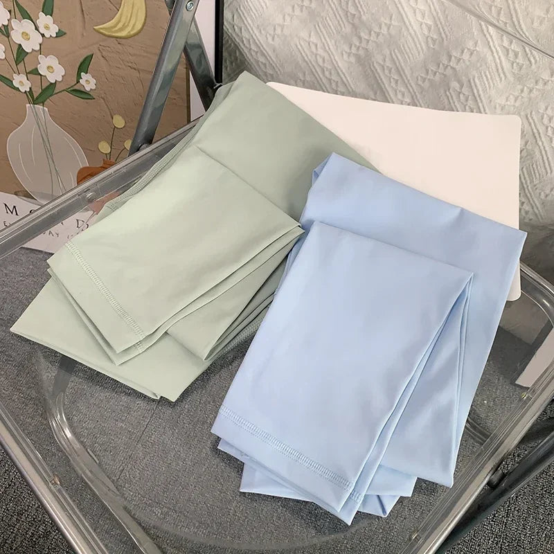 Stack of light green and blue folded towels on a glass surface.