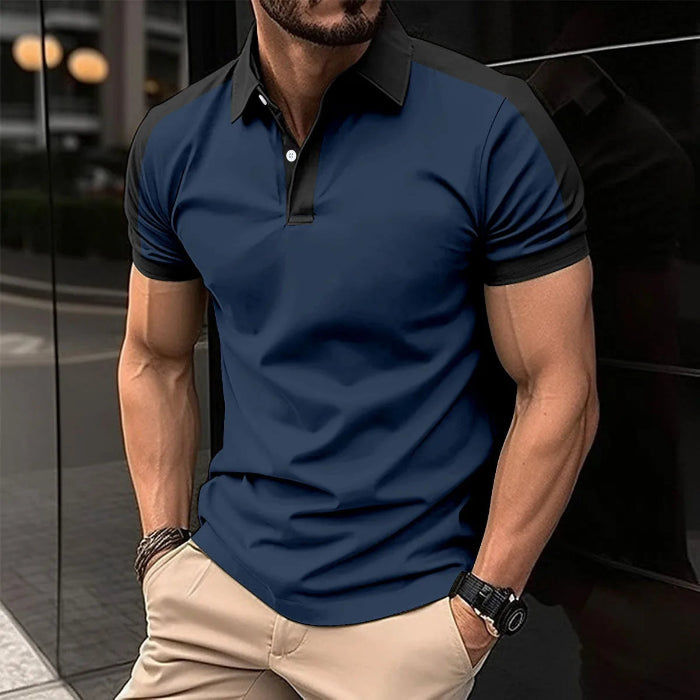 A man wearing a red and black patchwork polo shirt with short sleeves and a collar.