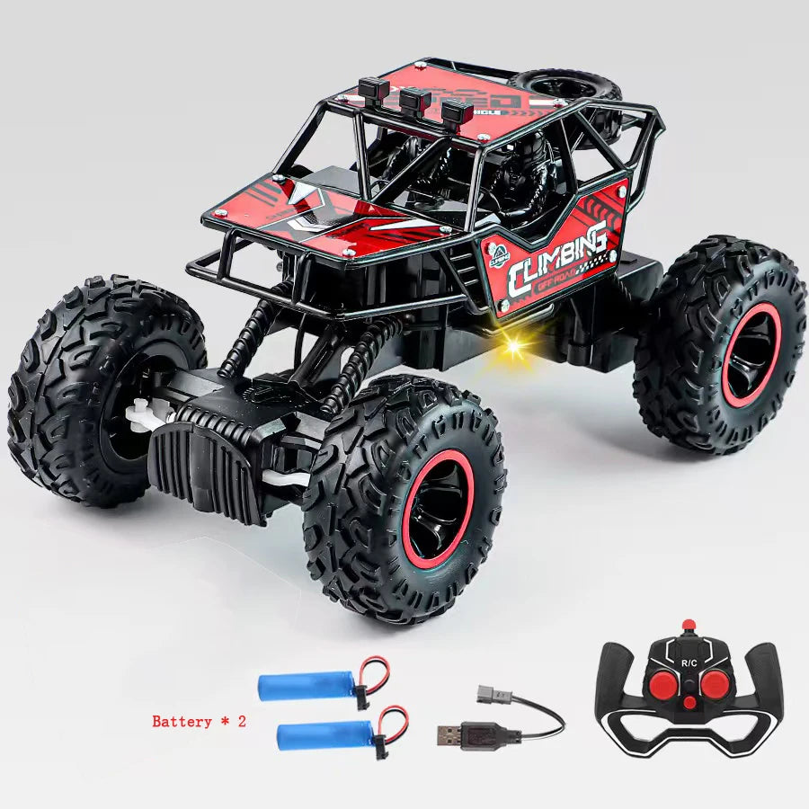 Toy monster truck with large wheels, remote control, and battery pack on a light gray background