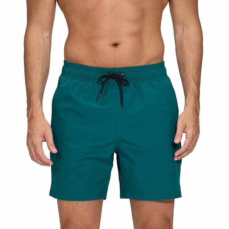 Teal swim shorts with a drawstring on a white background