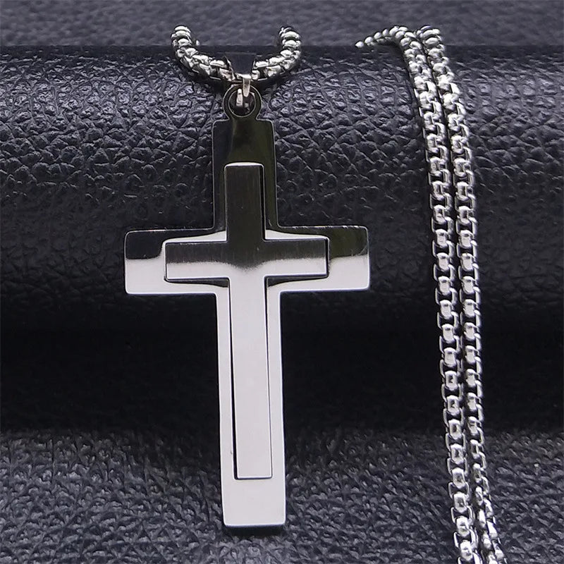 Silver cross pendant with chain on a textured black background