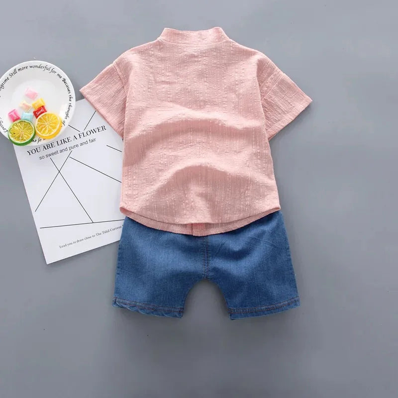 Pink shirt and blue shorts set on a gray background
