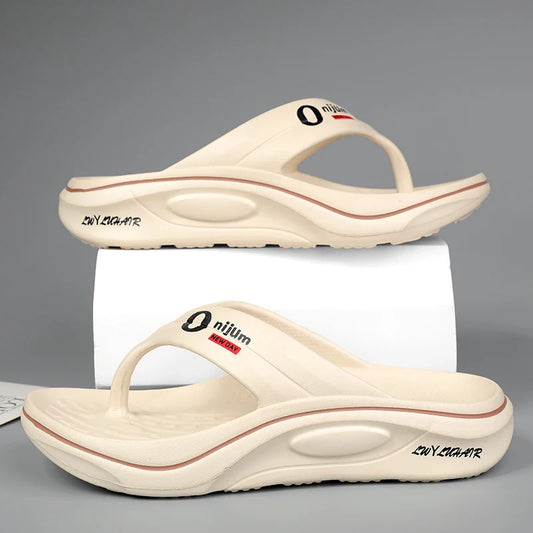 Pair of beige sandals with red accents on a gray background