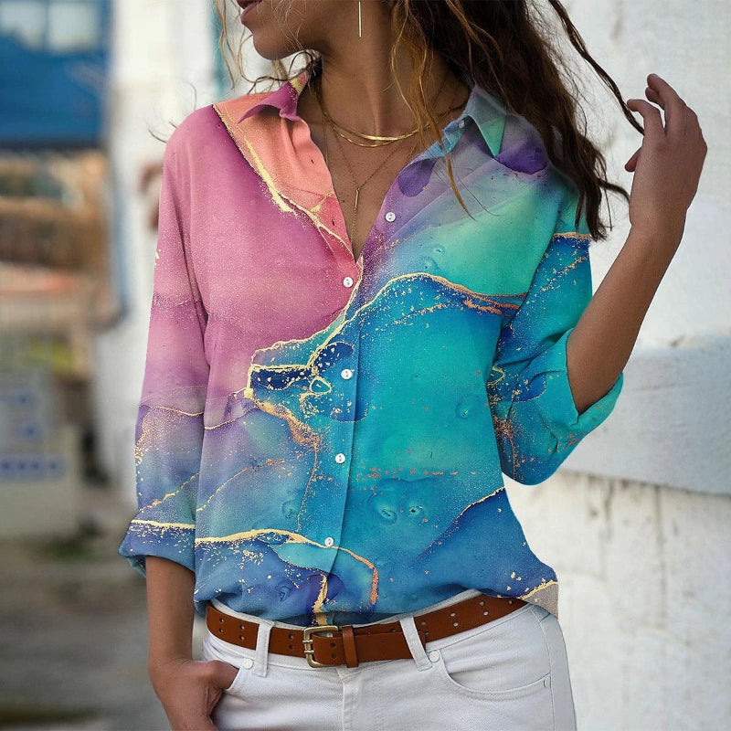 Woman wearing a colorful abstract patterned shirt with a blurred background