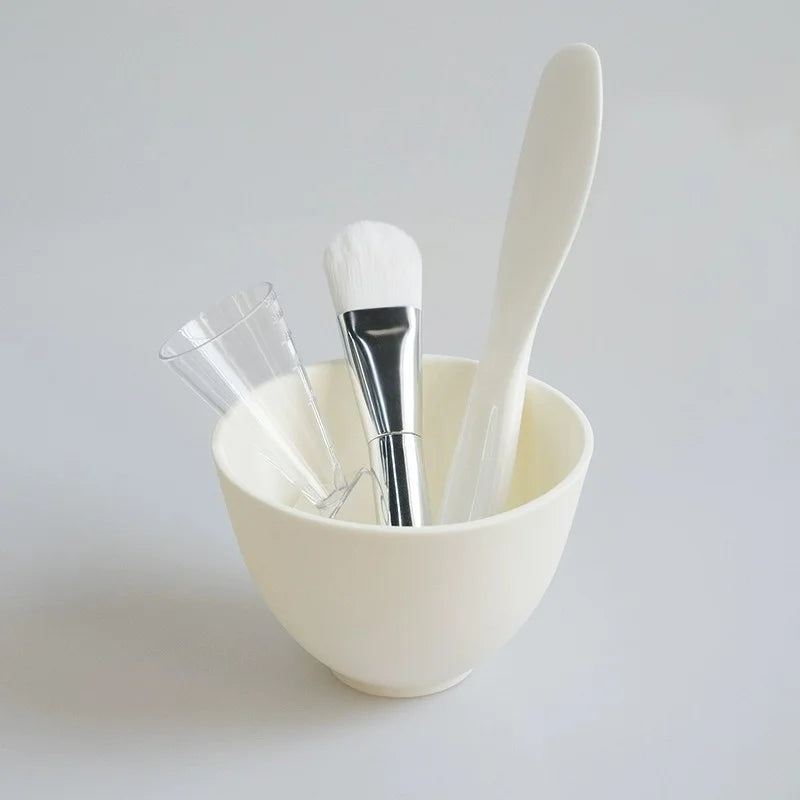 White bowl with various makeup tools on a light gray background