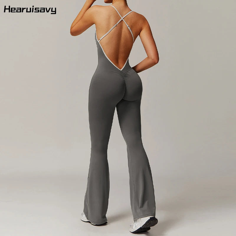 Person wearing a gray jumpsuit with a backless design on a plain background