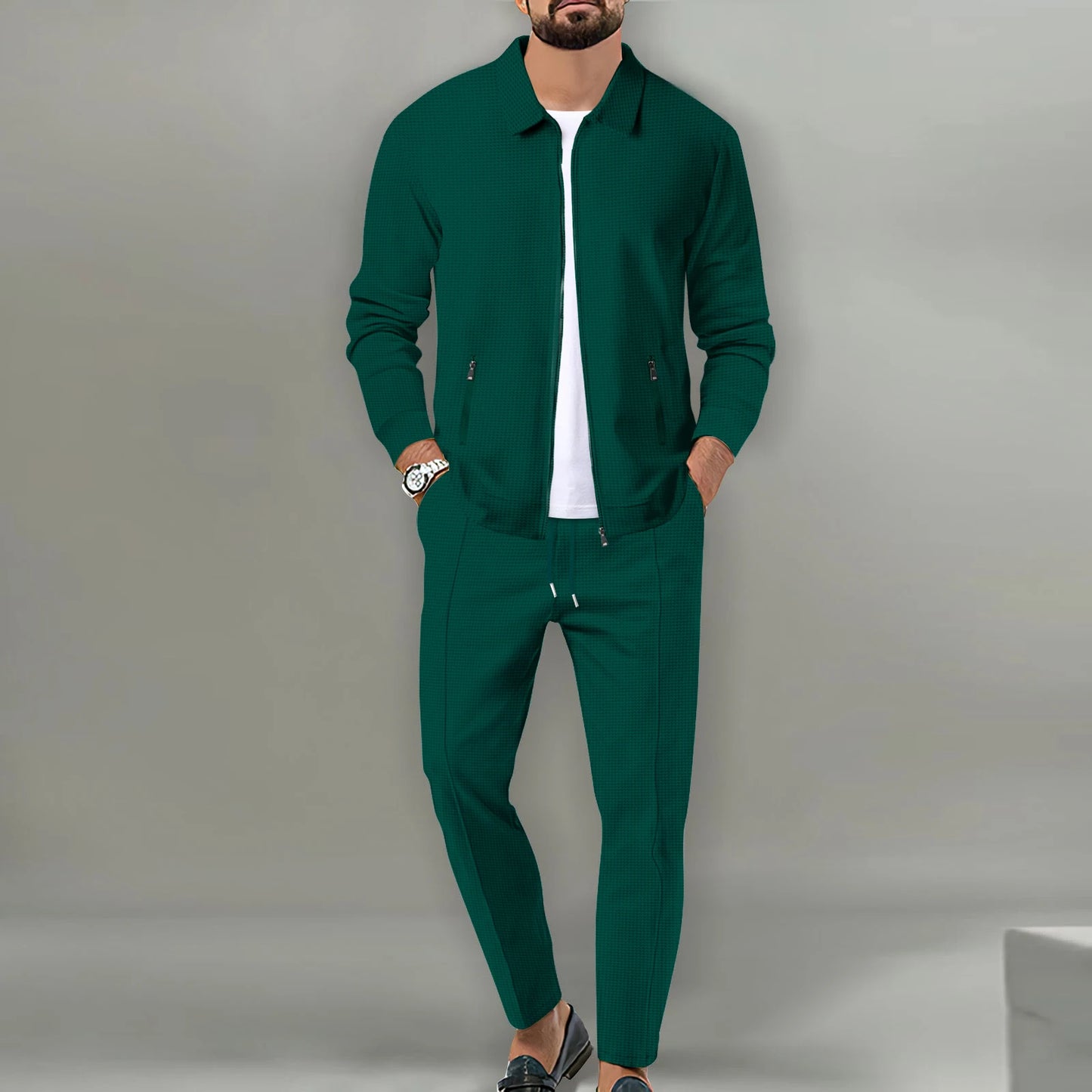 Man wearing a green tracksuit against a gray background