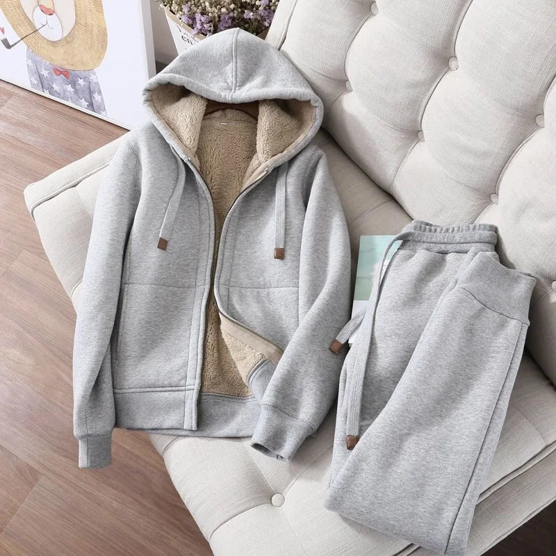 Gray hoodie and pants set on a couch with a neutral background