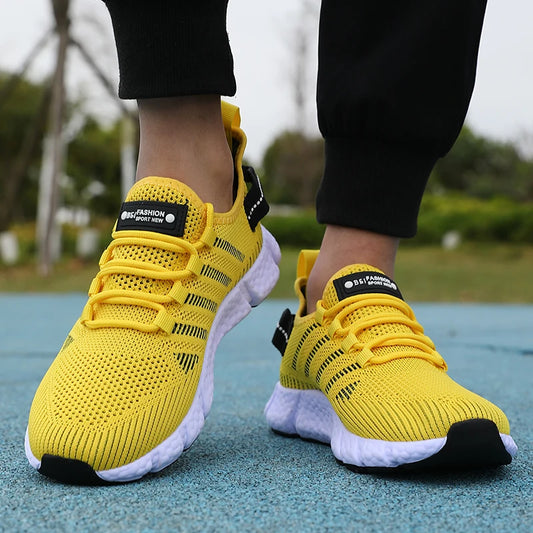 Yellow running shoes with black accents on a blurred outdoor background