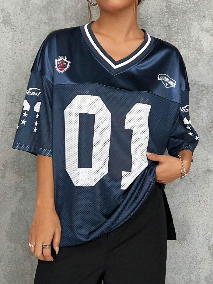 A woman wearing a black V-neck sports jersey with the number '01' on it. The jersey has white text and trim, and it appears to be made of polyester fabric.