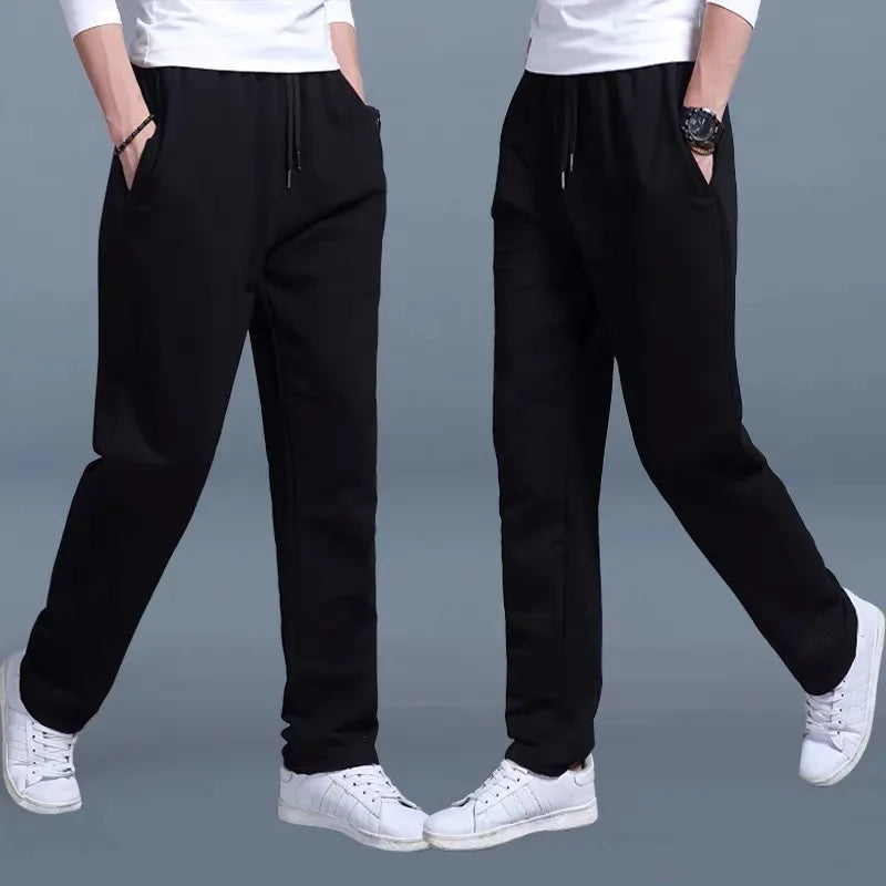 Black jogger pants worn by a person on a gray background