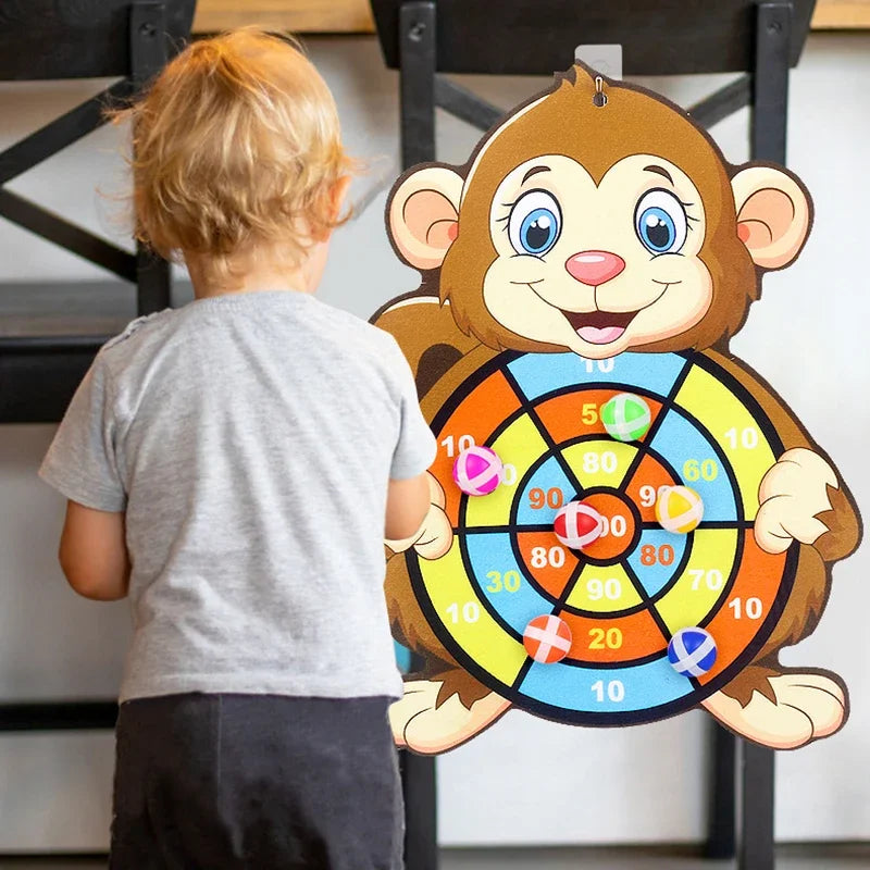 Child playing with a monkey-themed dart board