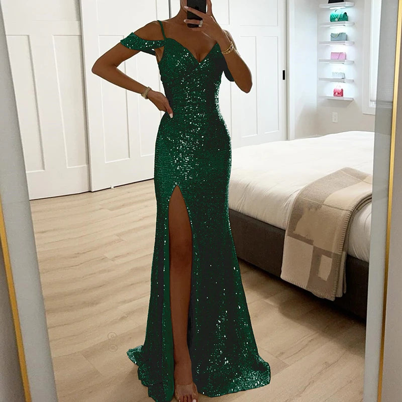 Person wearing a green sequin dress with a high slit in a bedroom setting.