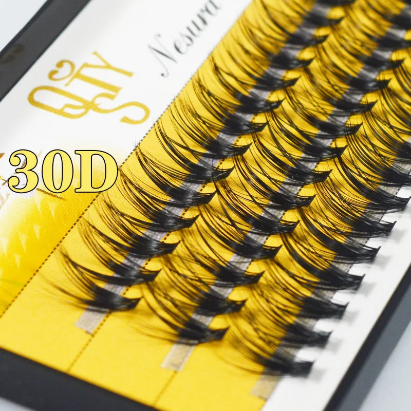 Eyelash extensions with a yellow and black design on a branded card.