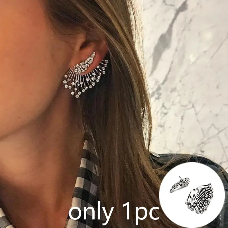Close-up of a woman wearing silver earrings with a marble background