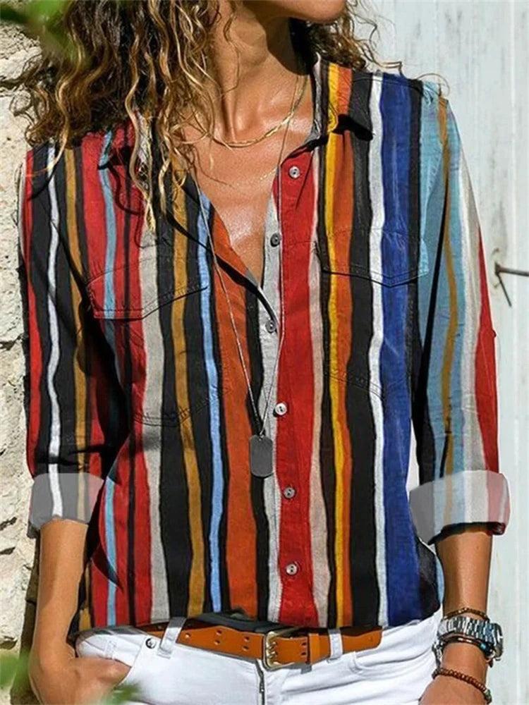 Woman wearing a colorful striped shirt with a blurred background