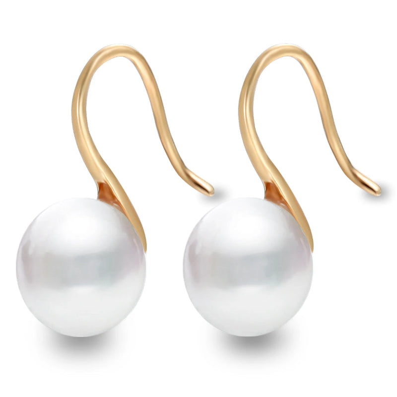 Gold earrings with white pearls on a white background