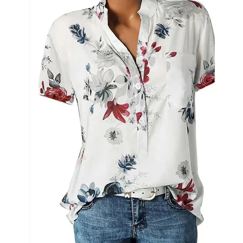 White blouse with colorful floral pattern worn by a person on a white background