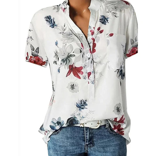 White blouse with colorful floral pattern worn by a person on a white background