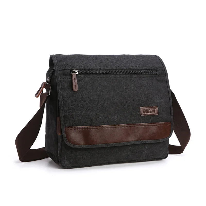 Black canvas messenger bag with brown leather accents on a white background