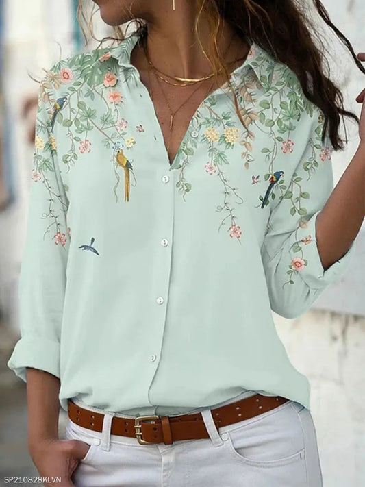 Light green shirt with floral and bird embroidery worn by a person.