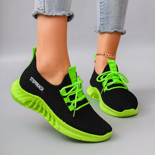 Black and green sneakers with bright green laces on a neutral background