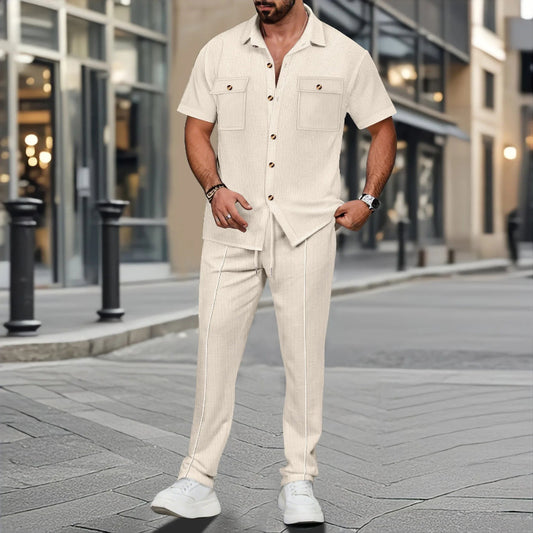 Man wearing a beige outfit standing on a city street.