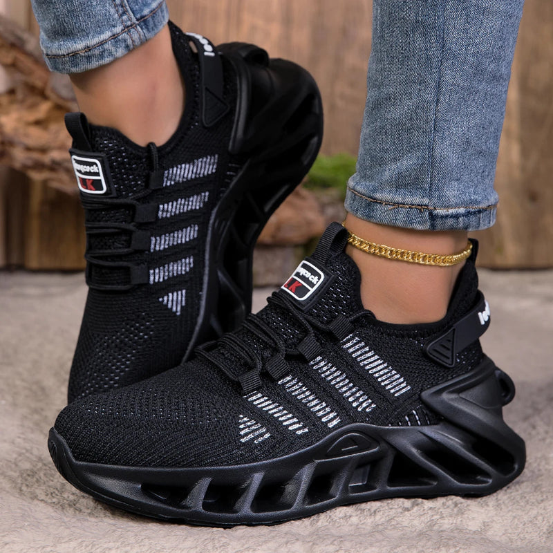Black athletic shoes with unique sole design worn by a person on a neutral background