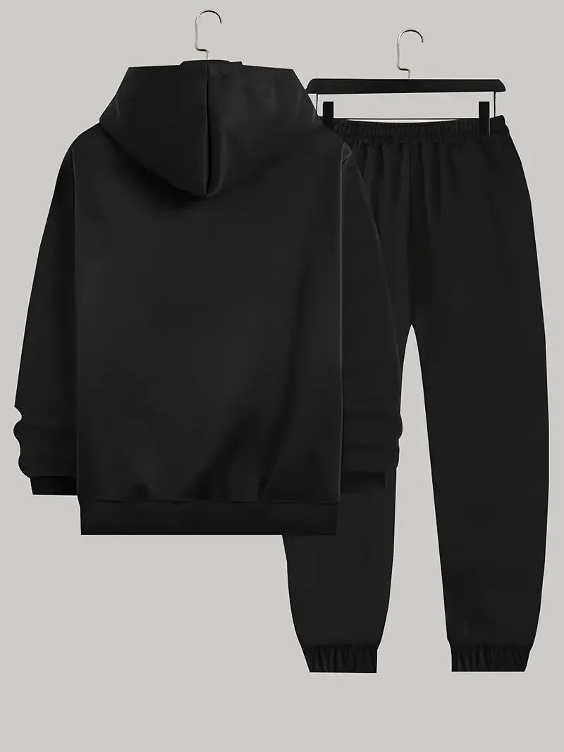 Black hoodie and jogger pants set on hangers against a light gray background