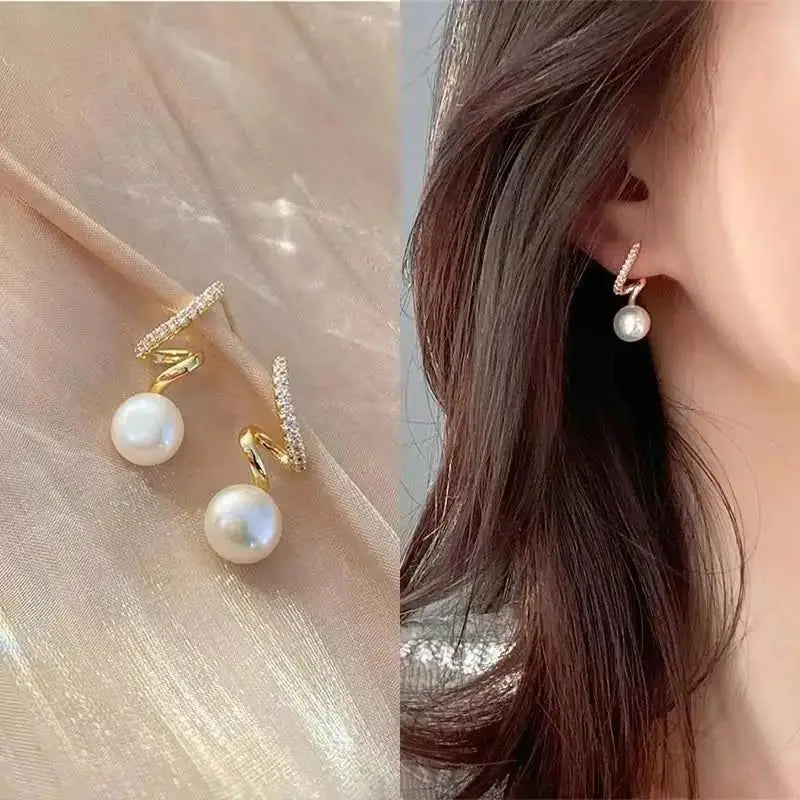 Pearl earrings with gold accents worn by a person, close-up view.