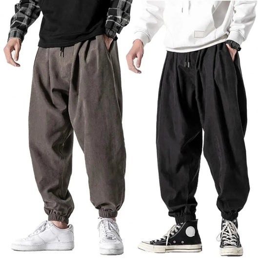 Two pairs of baggy pants in gray and black on a white background.