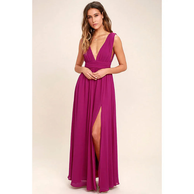 Woman wearing a vibrant pink gown with a deep neckline and slit on a beige background