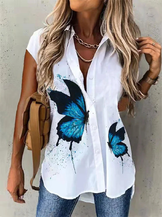 Woman wearing a white shirt with blue butterfly designs against a plain background