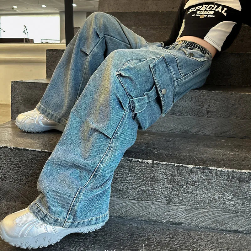 Person wearing blue jeans and white sneakers sitting on a staircase.