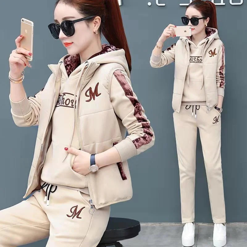 Woman in beige tracksuit with logo details, taking a selfie.