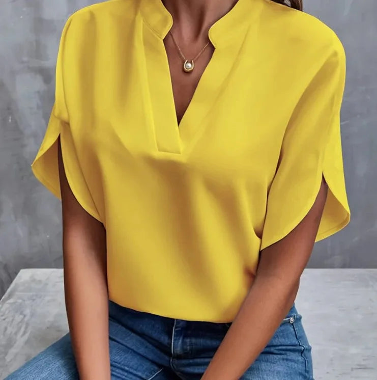 Person wearing a yellow blouse with a gray background