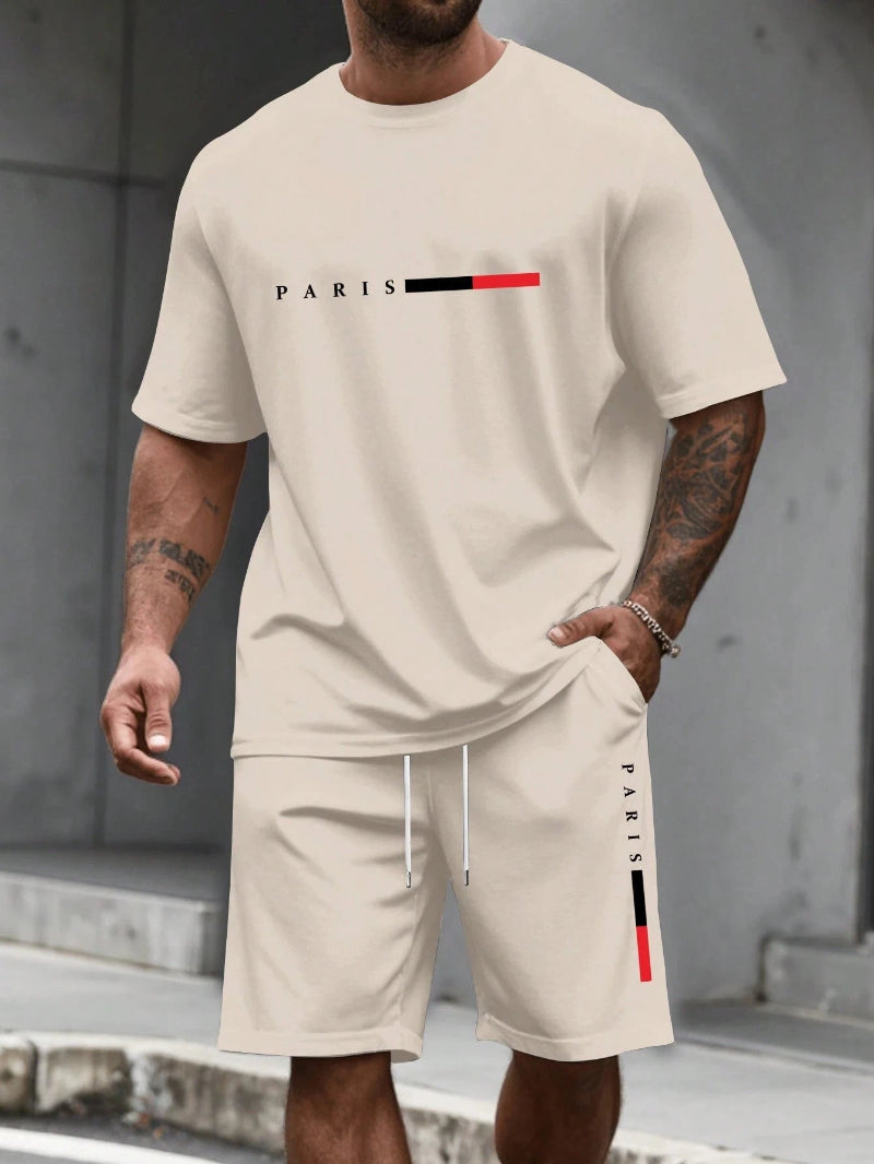 Person wearing a beige 'PARIS' t-shirt and shorts set with graphic design.