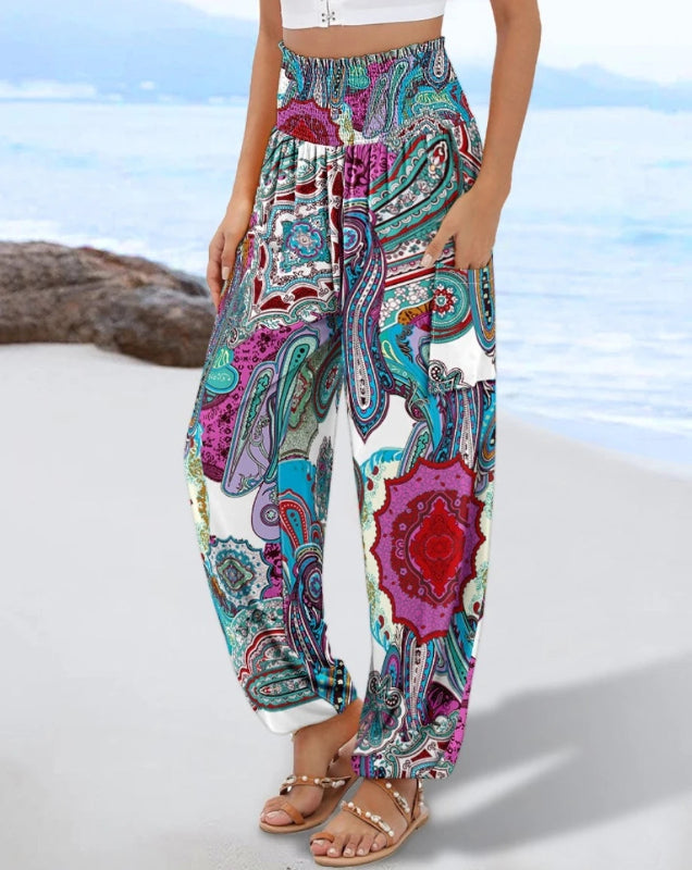 Colorful patterned pants worn by a person on a beach.