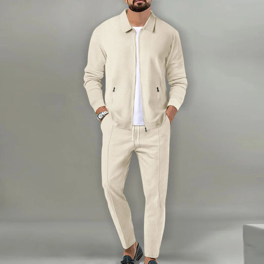 Man wearing a beige tracksuit against a gray background