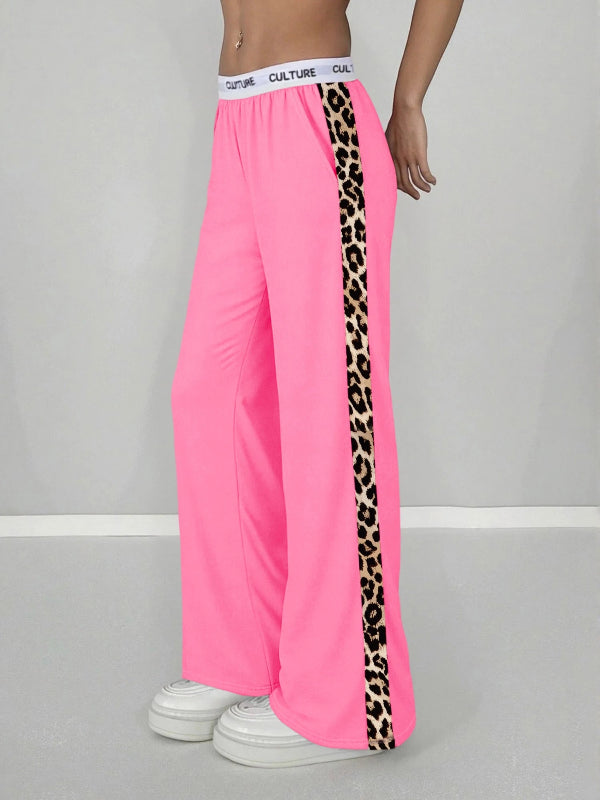 Pink wide-leg pants with leopard print side stripe on a gray background