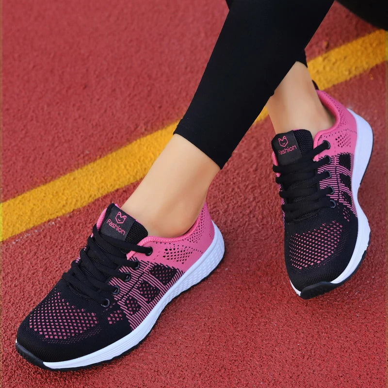 Pink and black athletic shoes on a red and yellow track surface