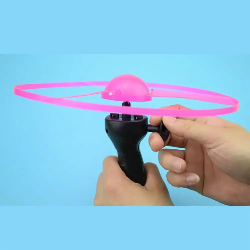 Pink flying disc held by a hand against a blue background