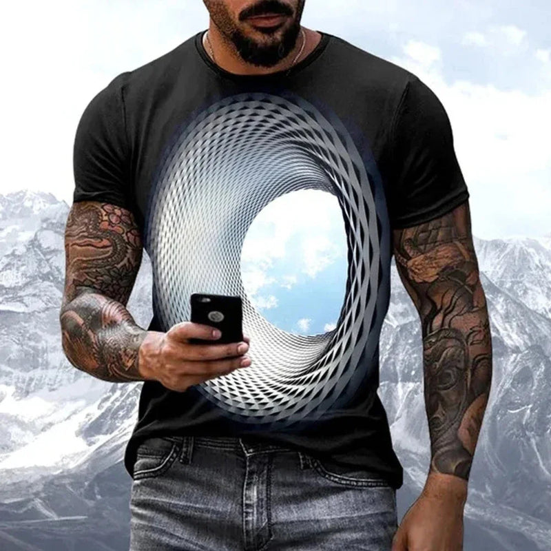 Man wearing a black t-shirt with a geometric design, holding a phone with a mountainous background.