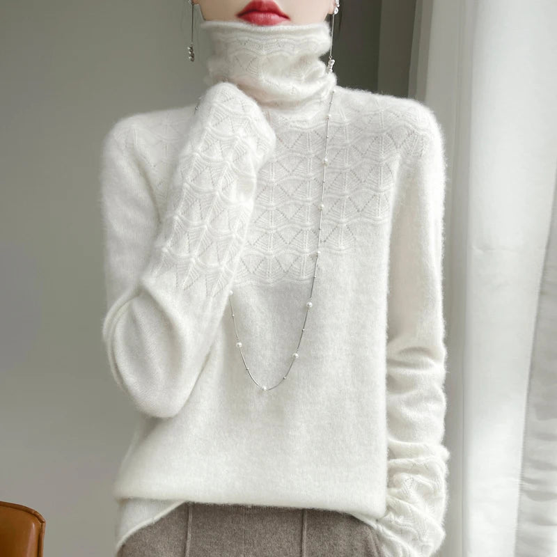 White turtleneck sweater with textured pattern worn by a person, against a neutral background.
