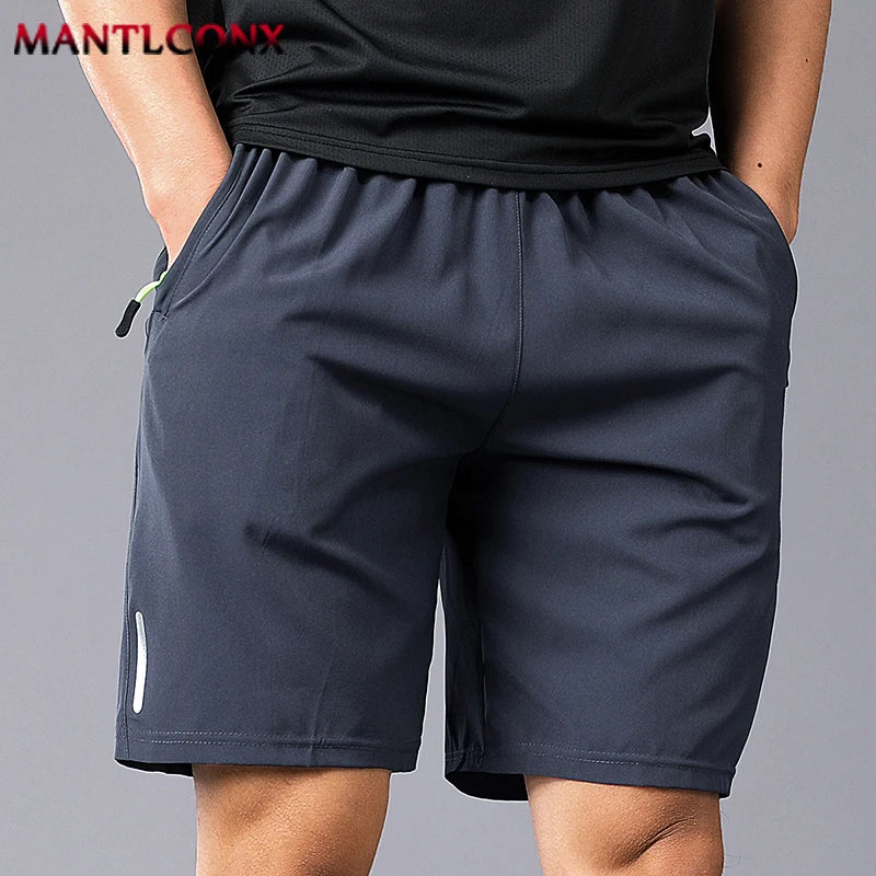 Person wearing navy shorts and a black top on a gray background with 'MANTLCONX' branding.