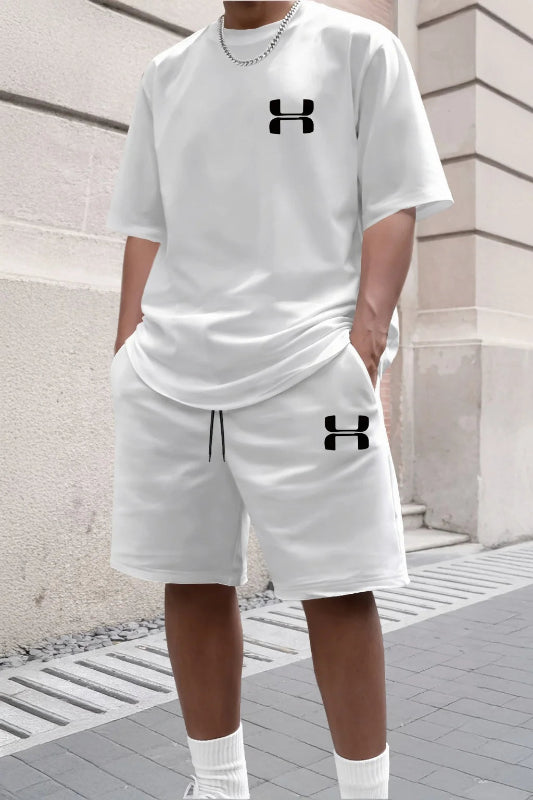 Person wearing a white Under Armour outfit with logo on a stone pavement background