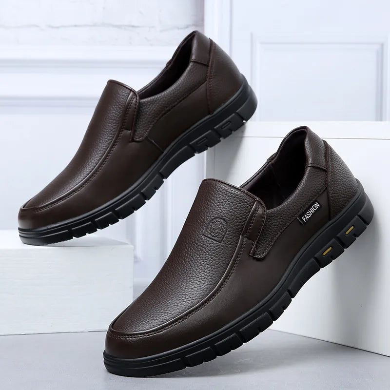 Brown leather shoes with black soles on a white background