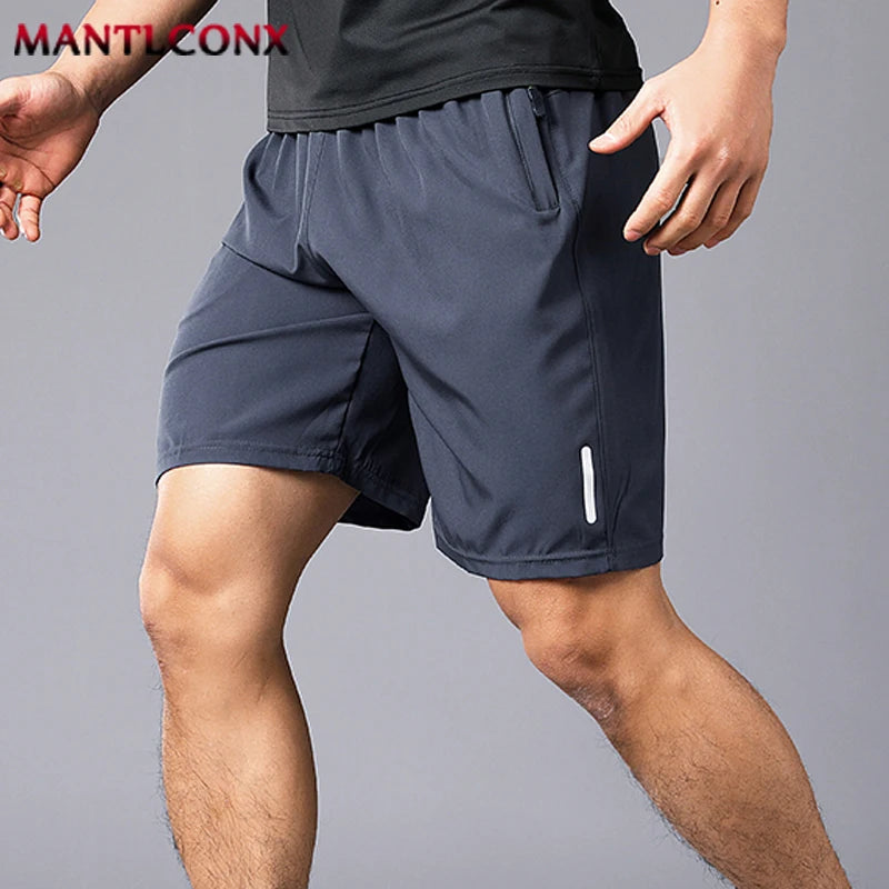 Person wearing dark gray athletic shorts on a gray background with 'MANTICONX' branding.