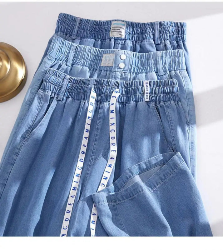 Blue denim pants with a visible brand label on a white background