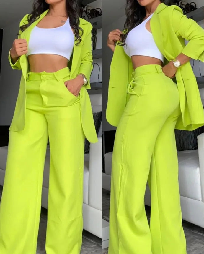 Woman wearing a bright green suit with a white top in an indoor setting.